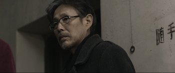 Movie still from “Coming Home” (2014), directed by Yimou Zhang – A person wearing glasses and a coat; Close Up shot, Over the shoulder angle