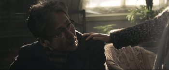 Movie still from “Coming Home” (2014), directed by Yimou Zhang – An older man with glasses is holding a woman's hand; Close Up shot, Over the shoulder angle