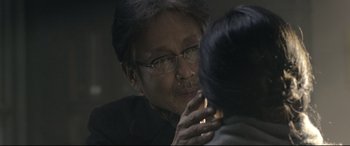 Movie still from “Coming Home” (2014), directed by Yimou Zhang – An older man looking in the mirror with glasses on his face; Close Up shot, Over the shoulder angle