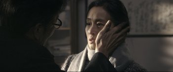 Movie still from “Coming Home” (2014), directed by Yimou Zhang – A woman holding her face with her hand; Close Up shot, Over the shoulder angle