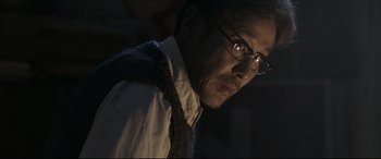 Movie still from “Coming Home” (2014), directed by Yimou Zhang – A person wearing glasses and a tie; Close Up shot, Low angle