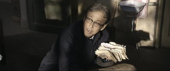 Movie still from “Coming Home” (2014), directed by Yimou Zhang – An older man is holding a stack of papers; Medium shot, Low angle