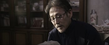 Movie still from “Coming Home” (2014), directed by Yimou Zhang – A person looking at a piece of paper; Close Up shot, Low angle