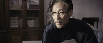 Movie still from “Coming Home” (2014), directed by Yimou Zhang – A person wearing glasses; Close Up shot, Over the shoulder angle