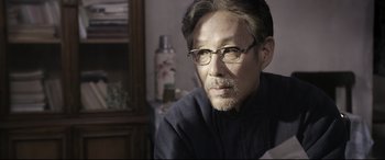 Movie still from “Coming Home” (2014), directed by Yimou Zhang – An older man wearing glasses looking at the camera; Close Up shot, Over the shoulder angle