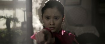 Movie still from “Coming Home” (2014), directed by Yimou Zhang – A young girl in a red shirt is holding a knife in her hand; Close Up shot, Low angle