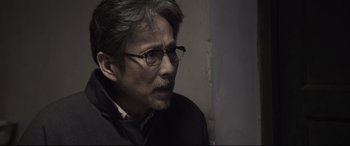 Movie still from “Coming Home” (2014), directed by Yimou Zhang – An older man wearing glasses and a black jacket; Close Up shot, Over the shoulder angle