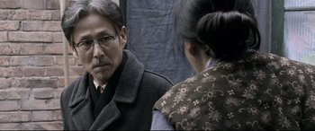 Movie still from “Coming Home” (2014), directed by Yimou Zhang – A man and a woman looking at one another in the mirror; Close Up shot, Over the shoulder angle