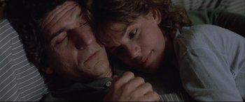 Movie still from “Communion” (1989), directed by Philippe Mora – A man and a woman laying on a bed; Close Up shot, High angle