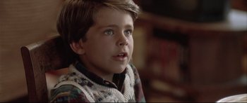 Movie still from “Communion” (1989), directed by Philippe Mora – A young boy is looking into the distance; Close Up shot, Low angle