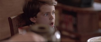Movie still from “Communion” (1989), directed by Philippe Mora – A young boy looking at the camera with a surprised look on his face; Close Up shot, Low angle