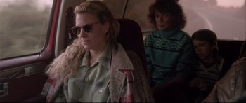 Movie still from “Communion” (1989), directed by Philippe Mora – A woman sitting next to another woman on a plane; Medium shot, Over the shoulder angle