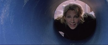 Movie still from “Communion” (1989), directed by Philippe Mora – A woman in black shirt looking out from a slide; Close Up shot, Low angle