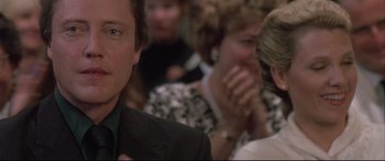 Movie still from “Communion” (1989), directed by Philippe Mora – A person wearing a suit and tie; Close Up shot, Over the shoulder angle