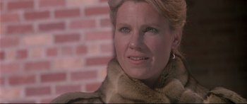 Movie still from “Communion” (1989), directed by Philippe Mora – A person wearing a fur coat; Close Up shot, Low angle