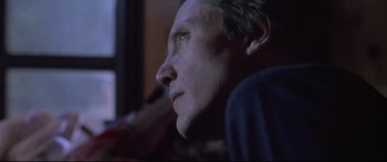 Movie still from “Communion” (1989), directed by Philippe Mora – A man's face as he watches something on a television; Close Up shot, Low angle