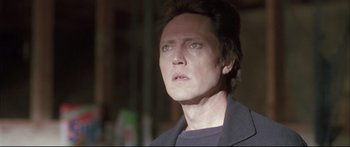 Movie still from “Communion” (1989), directed by Philippe Mora – A person with short dark hair; Close Up shot, Low angle