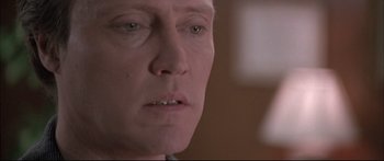 Movie still from “Communion” (1989), directed by Philippe Mora – A man's face in a dark room; Close Up shot, Low angle