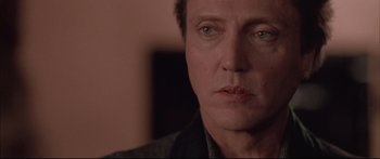 Movie still from “Communion” (1989), directed by Philippe Mora – A man's face in a dark room; Close Up shot, Low angle