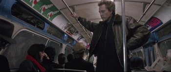 Movie still from “Communion” (1989), directed by Philippe Mora – A man standing on top of a train next to a woman; Medium shot, Low angle