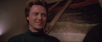 Movie still from “Communion” (1989), directed by Philippe Mora – A person smiling for the camera; Close Up shot, Low angle