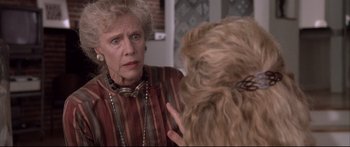 Movie still from “Communion” (1989), directed by Philippe Mora – An older woman talking to a younger woman in front of a mirror; Close Up shot, Over the shoulder angle
