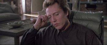 Movie still from “Communion” (1989), directed by Philippe Mora – A person sitting on a couch with his eyes closed; Close Up shot, Low angle