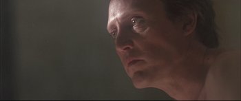 Movie still from “Communion” (1989), directed by Philippe Mora – A man's face looking up; Close Up shot, Low angle