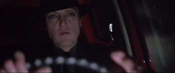 Movie still from “Communion” (1989), directed by Philippe Mora – A man in a hat looking into a mirror in a car; Close Up shot, Low angle