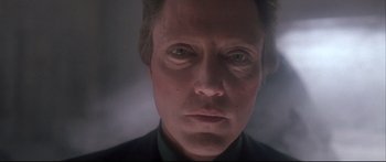 Movie still from “Communion” (1989), directed by Philippe Mora – A man's face in a dark room; Close Up shot, Low angle