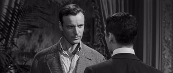 Movie still from “Compulsion” (1959), directed by Richard Fleischer – A man in a suit and tie talking to another man in a suit and tie; Close Up shot, Over the shoulder angle