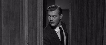 Movie still from “Compulsion” (1959), directed by Richard Fleischer – A black and white photo of a man in a suit and tie; Close Up shot, Over the shoulder angle