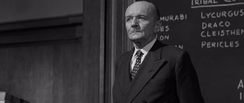 Movie still from “Compulsion” (1959), directed by Richard Fleischer – An older man wearing a suit and tie; Medium shot, Low angle