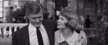 Movie still from “Compulsion” (1959), directed by Richard Fleischer – An older man and a younger woman smiling for the camera; Close Up shot, Over the shoulder angle