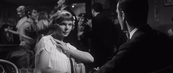 Movie still from “Compulsion” (1959), directed by Richard Fleischer – A woman in a white dress adjusting a man in a black suit; Close Up shot, Over the shoulder angle