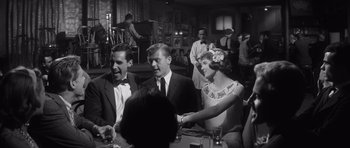 Movie still from “Compulsion” (1959), directed by Richard Fleischer – A group of people sitting around a table; Medium shot, Over the shoulder angle