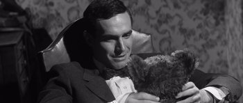 Movie still from “Compulsion” (1959), directed by Richard Fleischer – A man in a suit holding a teddy bear; Close Up shot, High angle