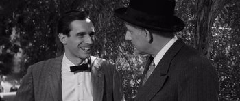 Movie still from “Compulsion” (1959), directed by Richard Fleischer – A man in a suit and a man in a hat talking to each other; Close Up shot, Over the shoulder angle