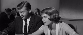 Movie still from “Compulsion” (1959), directed by Richard Fleischer – A man and a woman sitting next to each other in a room; Close Up shot, Low angle