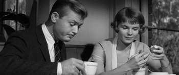 Movie still from “Compulsion” (1959), directed by Richard Fleischer – A man and a woman sitting at a table with a cup of coffee; Close Up shot, Low angle