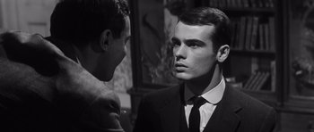 Movie still from “Compulsion” (1959), directed by Richard Fleischer – A man in a suit and tie standing next to another man in a suit and tie; Close Up shot, Over the shoulder angle