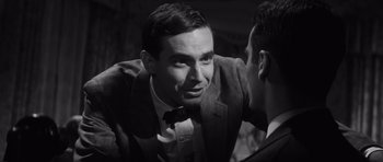 Movie still from “Compulsion” (1959), directed by Richard Fleischer – A man wearing a suit and tie talking to another man; Close Up shot, Over the shoulder angle