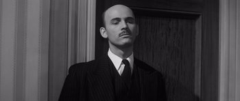 Movie still from “Compulsion” (1959), directed by Richard Fleischer – A man in a suit and tie with a goatee; Close Up shot, Low angle