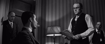Movie still from “Compulsion” (1959), directed by Richard Fleischer – Two men in a room with a lamp; Medium shot, Over the shoulder angle