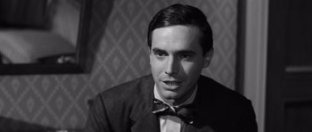 Movie still from “Compulsion” (1959), directed by Richard Fleischer – A black and white photo of a man wearing a suit and bow tie; Close Up shot, Over the shoulder angle