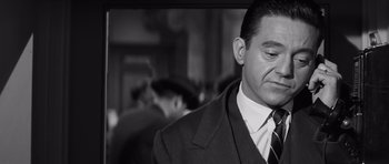 Movie still from “Compulsion” (1959), directed by Richard Fleischer – Black and white photograph of a man wearing a suit and tie; Close Up shot, Over the shoulder angle