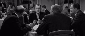 Movie still from “Compulsion” (1959), directed by Richard Fleischer – A black - and - white photo of two men at a table; Medium shot, Over the shoulder angle