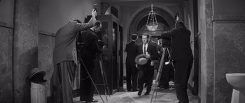 Movie still from “Compulsion” (1959), directed by Richard Fleischer – A black - and - white photo of a group of men in suits and ties; Wide shot, High angle