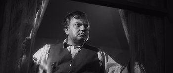Movie still from “Compulsion” (1959), directed by Richard Fleischer – A man in a vest and a tie looking to his left; Close Up shot, Low angle