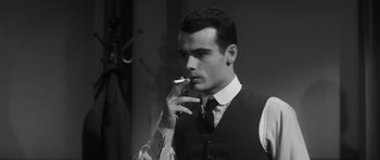 Movie still from “Compulsion” (1959), directed by Richard Fleischer – A man smoking a cigarette while wearing a suit; Close Up shot, Low angle